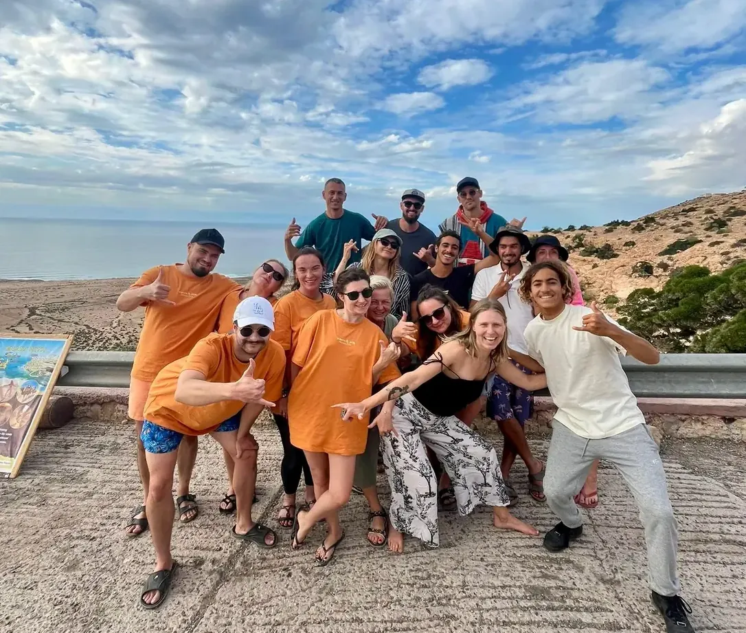 A group in hoodies and djellabas on the rocks at dusk